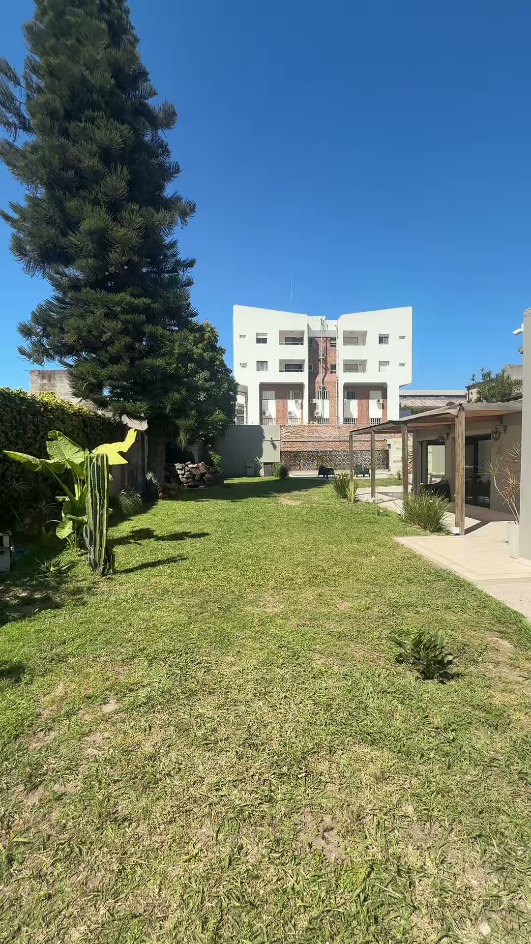 El jardín con la galería, la pérgola y el quincho al fondo